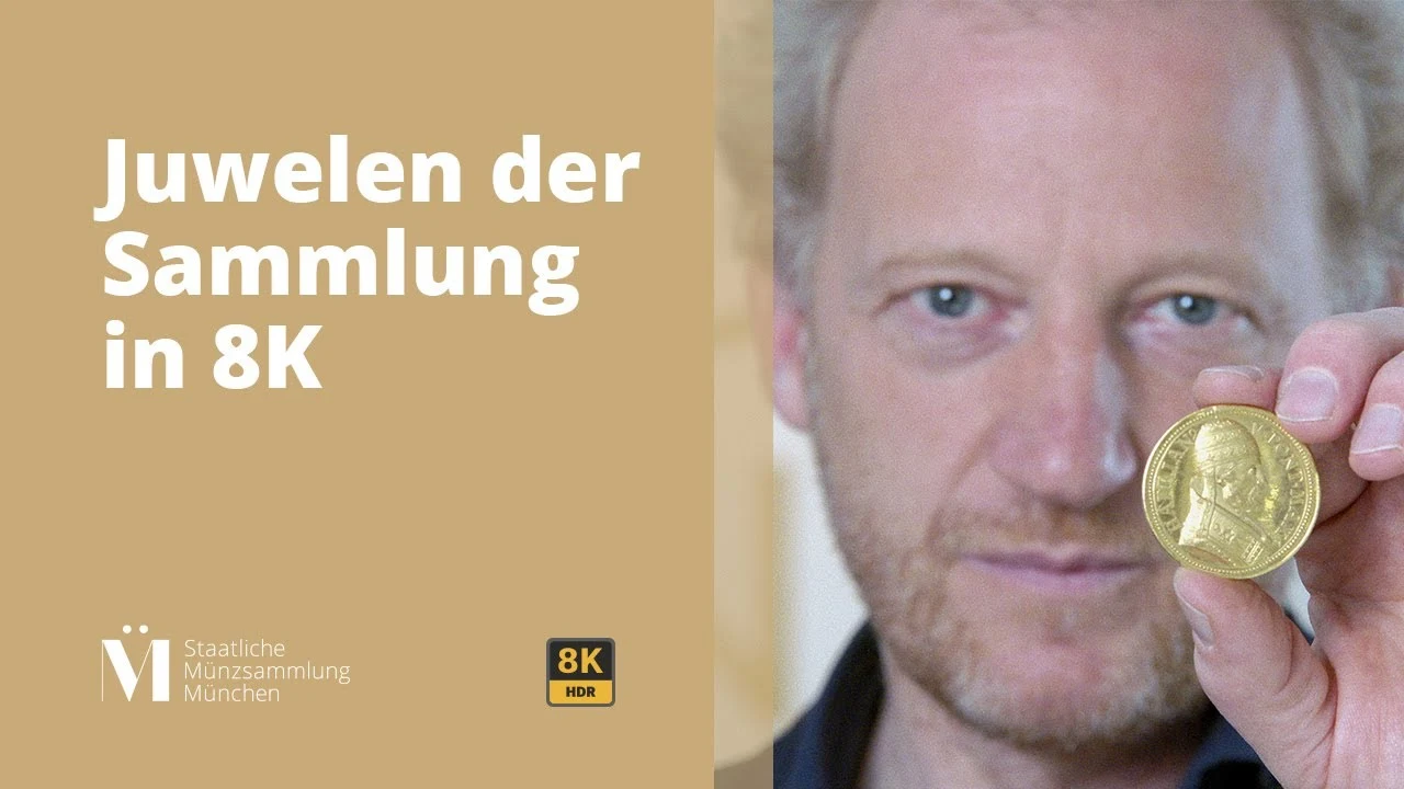 Originalvorschaubild der Staatlichen Münzsammlung München: Kurator Martin Hirsch mit einer Goldmünze